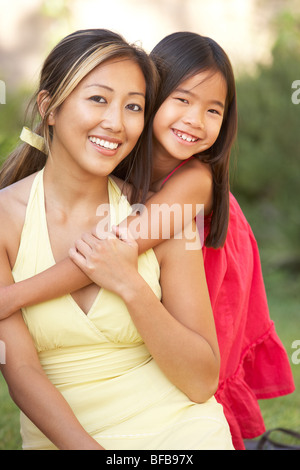 Madre e figlia abbracciando in giardino Foto Stock
