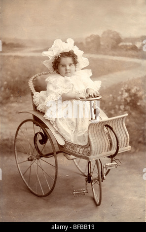 Little Girl Riding assurdo triciclo in vimini Foto Stock