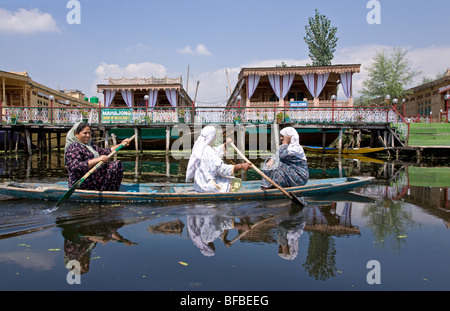 Donne paddling una barca (shikara). Dal Lago. Srinagar. Il Kashmir. India Foto Stock