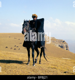 Cavallo Kabardine cavalcato da cosacco nelle montagne del Caucaso, che indossa abiti tradizionali Foto Stock