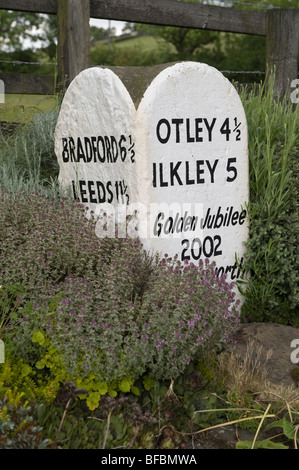 Primo piano sulla pietra miliare del Giubileo (tappa dei villaggi rurali, distanze dalle città locali, numero di miglia, pulito) - Hawksworth vicino a Leeds, West Yorkshire, Inghilterra Regno Unito Foto Stock