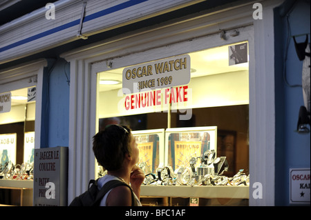 Donna guarda attraverso la finestra di un negozio di vendita orologi contraffatti nel centro di Kalkan Foto Stock