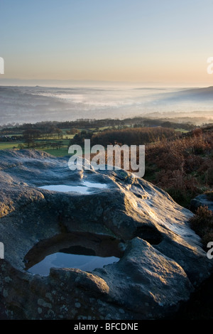 Sunrise, e la nebbia riempie la valle di Wharfedale. Una vista da Ilkley Moor nel West Yorkshire, Inghilterra Foto Stock