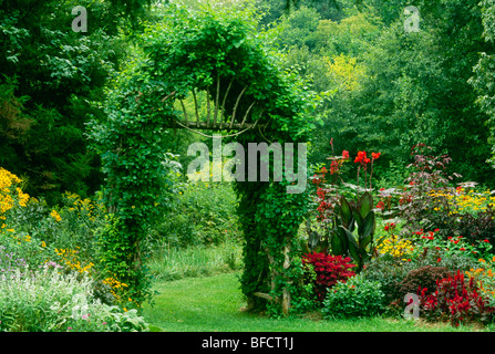 Lussureggiante giardino fiorito è dato un senso di maggiore spazio e privacy con mandrino a mano utilizzando rami dagli alberi, Missouri USA Foto Stock