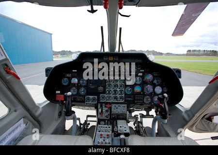 Cabina di pilotaggio e quadro strumenti di un elicottero bimotore AgustaWestland A109A ad uso privato, che mostra i controlli di volo dettagliati e l'avionica mentre è parcheggiato. Foto Stock