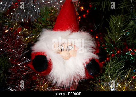 Toy santa decorazione appeso a un albero di Natale artificiale Foto Stock