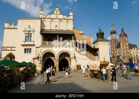 Parte anteriore del Sukiennice (panno Hall, Trasportatori' Hall) nella piazza principale del mercato. Cracovia. La Polonia. St Marys Basilica è a destra. Foto Stock