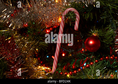 Candy Cane decorazione appeso a un albero di Natale artificiale Foto Stock