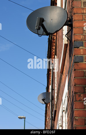 Parabola satellitare piatti sul lato di una terrazza house di Sneinton, Nottingham, Nottinghamshire. Foto Stock