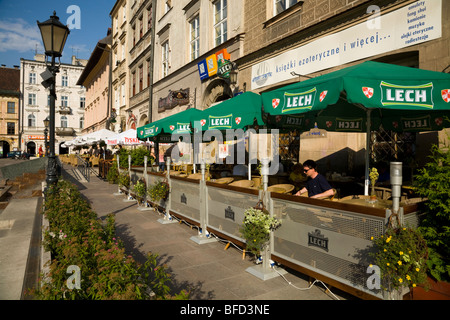 Aria aperta pavement cafe bar tabelle con ombrelloni in piazza delimitata da Beskid Rynek. Cracovia. La Polonia. Foto Stock