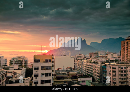 Vista sui tetti di edifici residenziali e le montagne al tramonto a Ipanema a Rio de Janeiro in Brasile Foto Stock