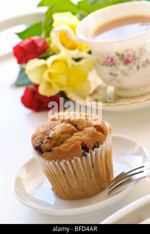 Muffin cotti al forno con uno stile Inglese del tè e fiori sul vassoio Foto Stock