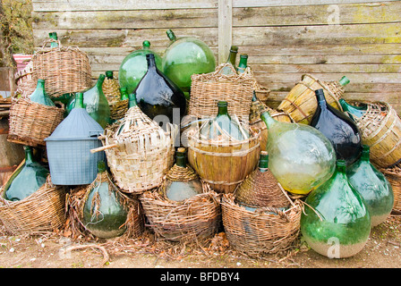 Scartato damigiane verde con basi di cestello Foto Stock