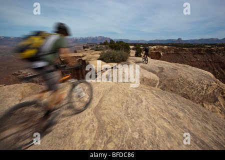 Due persone in mountain bike verso il basso una roccia nei pressi di uragano, Utah. Foto Stock