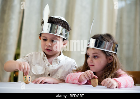 Un ragazzo e una ragazza che gioca con un dreidel. Foto Stock