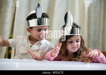 Un ragazzo e una ragazza che gioca con un dreidel. Foto Stock