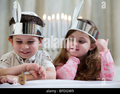 Un ragazzo e una ragazza che gioca con un dreidel. Foto Stock