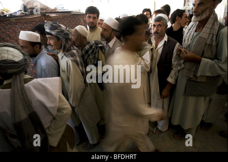 Gli uomini afghani attendere in linea di voto presso una scuola locale il giorno delle elezioni presidenziali e provinciali di Mazar-i Sharif, afgani Foto Stock