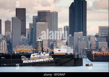 Un rimorchiatore e ancoraggio chiatta off Alki Point nella Baia di Elliott. Il Seattle, Washington skyline può essere visto in background. Foto Stock