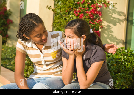 Appendere appendere fuori insieme African American 13-15 anno vecchia ragazza ascolta i comfort di ascolto triste amico. California MR Foto Stock