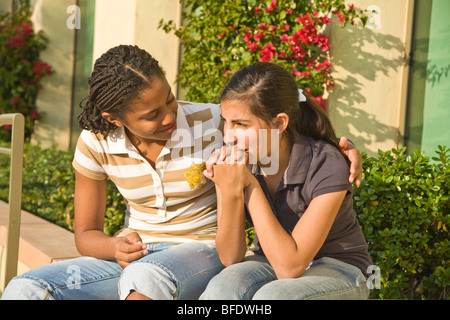 Appendere appendere fuori insieme americano africano con trecce 13-15 anni comfort ragazza triste ragazza. California MR Foto Stock