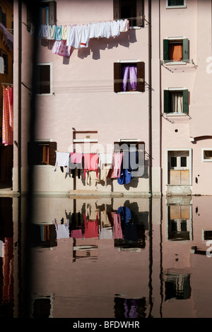 Servizio lavanderia essiccazione di una casa su uno stendibiancheria con riflesso nell'acqua Foto Stock