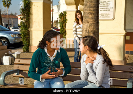 Le ragazze della scuola appendere appendere fuori ignorato razziale variegato gruppo di ragazze adolescenti a parlare mentre una ragazza triste si sente lasciato fuori animata . California MR Foto Stock