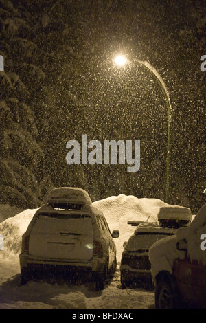 In notturna di nevicate invernali in un parcheggio di Revelstoke, British Columbia, Canada Foto Stock