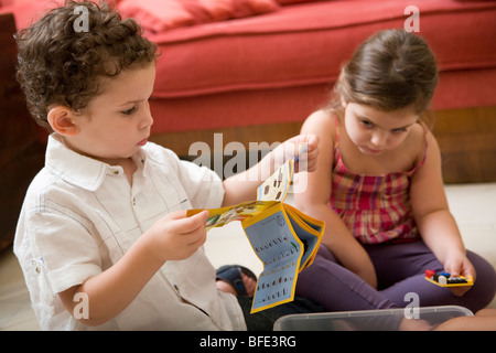 Ragazzo che guarda ad una costruzione manuale del gioco. Foto Stock