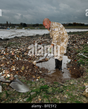 L uomo lo scavo per bottiglie di antiquariato in un dump di stile vittoriano. Abbassare Halstow, Kent, Inghilterra, Regno Unito. Foto Stock