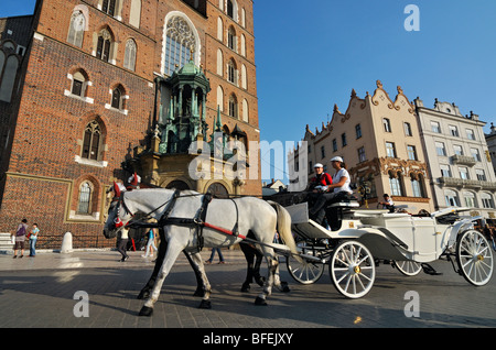 Carrozza a cavalli davanti la chiesa di Santa Maria in Piazza del mercato (Rynek Glowny) in Cracovia (Cracovia), Polonia Foto Stock