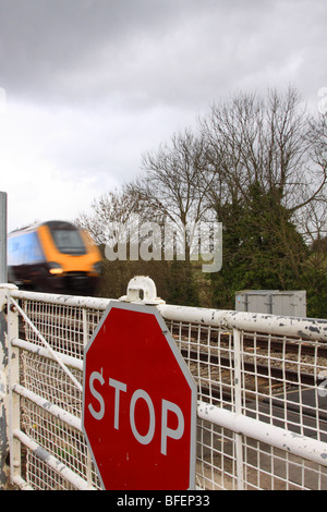 Treno passa presidiati gated passaggio a livello, Worcestershire, England Regno Unito Foto Stock