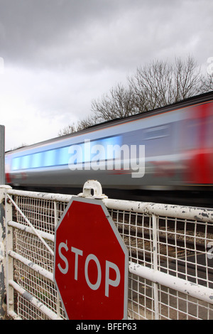 Treno passa presidiati gated passaggio a livello, Worcestershire, England Regno Unito Foto Stock