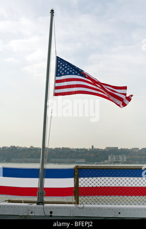 Noi sventola a metà il montante sulla poppa della nave USS New York per onorare le vittime del World Trade Center crollo Foto Stock