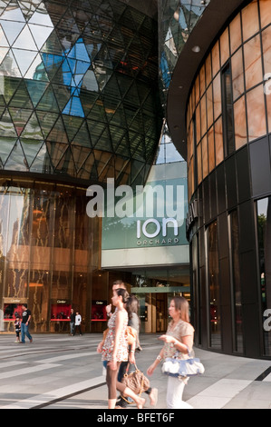 Gli amanti dello shopping dell'atrio al di fuori dell'entrata principale per lo ION Orchard shopping center building, Orchard Rd, Singapore Foto Stock