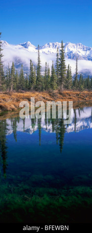 Prima neve su Miette gamma e la riflessione in un stagno lungo l'autostrada 16 vicino al fiume rocciose montagne rocciose del Parco Nazionale di Jasper un Foto Stock