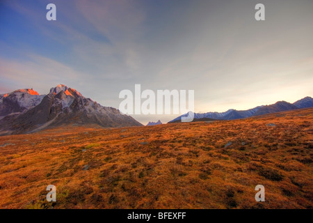 Ultimi raggi di luce solare che colpisce il picco del Monte monolito con lapide di montagna in distanza. Oggetto contrassegnato per la rimozione definitiva della Valle di Yukon durante la collezione autunno Foto Stock