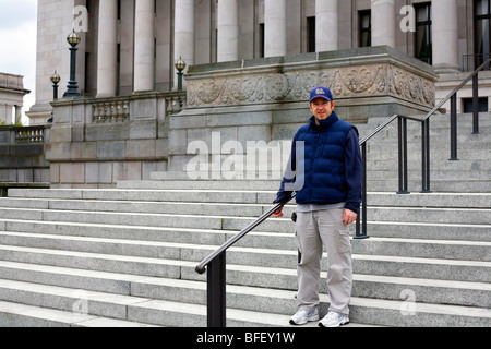 Uomo in piedi sui gradini del Washington State Capitol in Olympia, Washington. Foto Stock