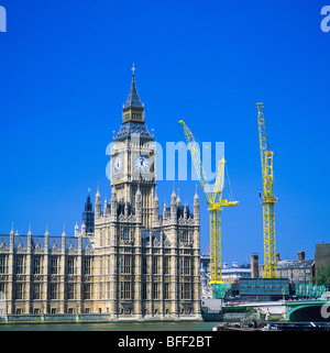 Case dei Comuni con il Big ben torre dell'orologio Westminster Palace E gru gialle Londra Inghilterra Gran Bretagna Foto Stock