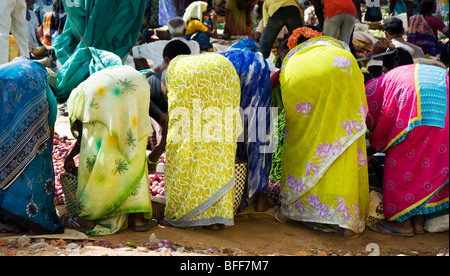 Le donne indiane piegamenti acquistare verdure da un mercato indiano. Puttaparthi, Andhra Pradesh, India Foto Stock