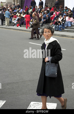 Lima, Perù, Plaza de Armas o Plaza Mayor: il Signore dei Miracoli 2006, una donna attraversare la strada Foto Stock