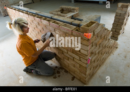 Una studentessa di apprendimento muratura pratico a 'City College Brighton' Foto Stock