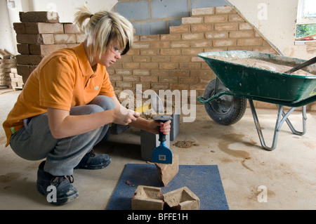 Una studentessa di apprendimento muratura pratico al City College Brighton Foto Stock