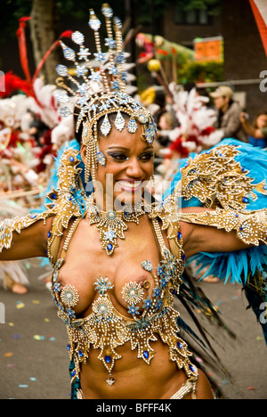 Una bella scarsamente abito donna da Paraiso la Scuola di Samba galleggiante durante il carnevale di Notting Hill a Londra in Inghilterra Foto Stock