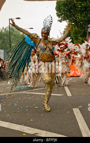 Una bella scarsamente abito donna da Paraiso la Scuola di Samba galleggiante durante il carnevale di Notting Hill a Londra in Inghilterra Foto Stock