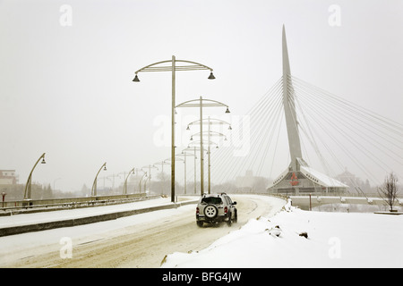 Jeep guidare oltre l'Esplanade Riel ponte in downtown Winnipeg, su un blustery, freddo giorno d'inverno. Winnipeg, Manitoba, Canada. Foto Stock