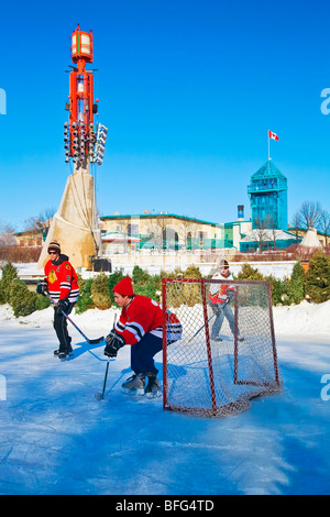 Giovani uomini la riproduzione di hockey su ghiaccio sul fiume Assiniboine, a forche in downtown Winnipeg, Manitoba, Canada. Foto Stock