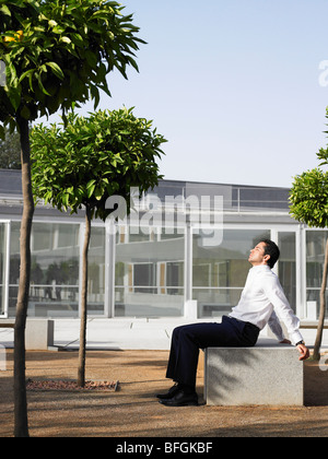 Imprenditore in seduta plaza rilassante nella luce del sole Foto Stock