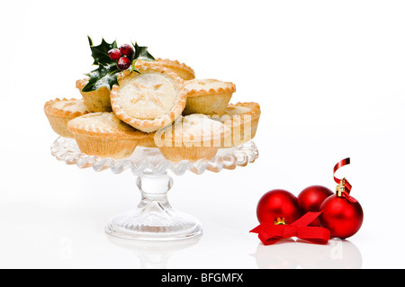 Pane appena sfornato Natale pasticci di carne macinata su vetro comport con red ninnolo decorazioni Foto Stock