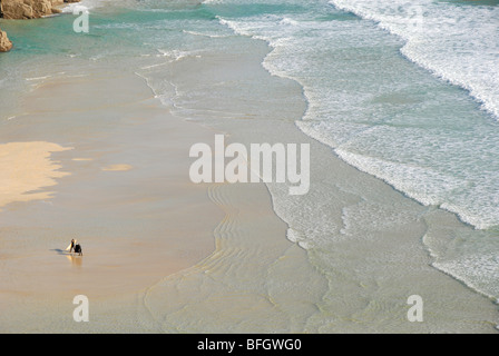 Due surfisti sulla spiaggia, onde, Porthcurno, Pedn Vounder Beach, Cornwall, England, Regno Unito Foto Stock